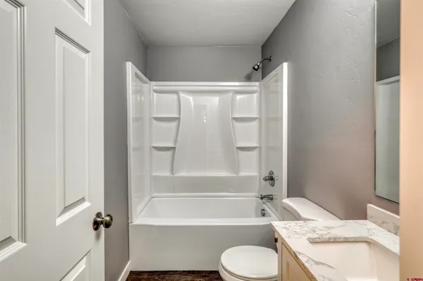 a bathroom with a granite countertop toilet sink and bathtub