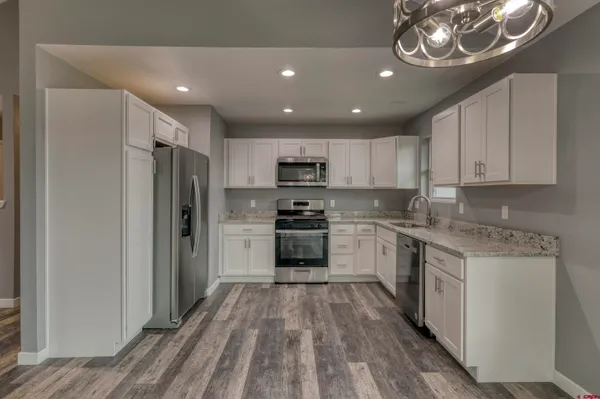a kitchen with a sink stainless steel appliances a refrigerator and a stove top oven