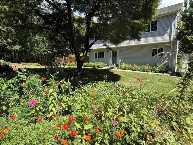 a backyard of a house with table and chairs and wooden fence