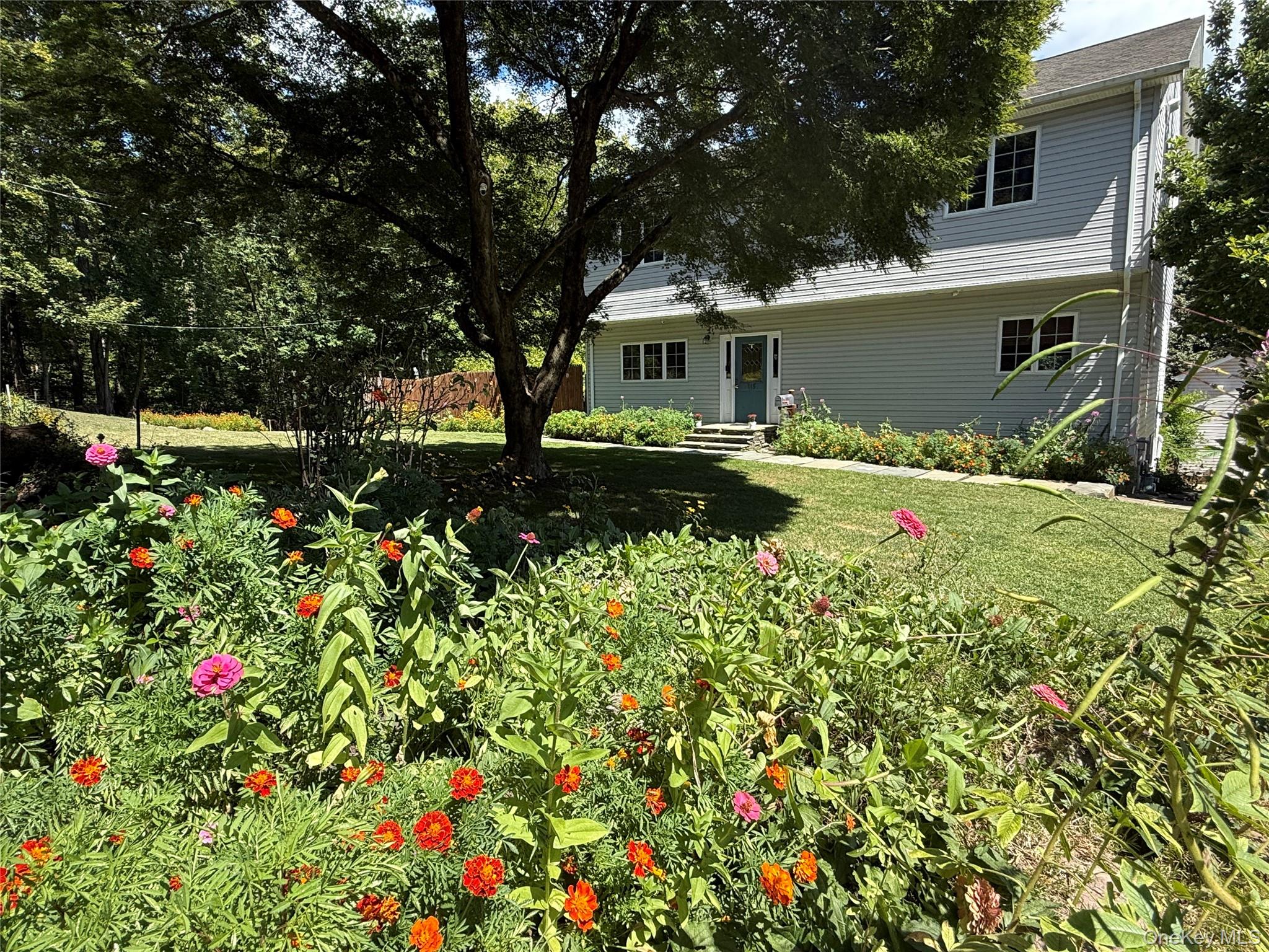 a backyard of a house with table and chairs and wooden fence