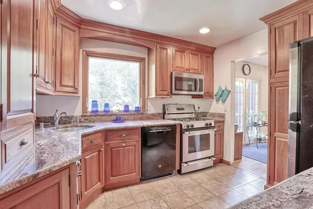 a kitchen with stainless steel appliances granite countertop a sink stove and refrigerator