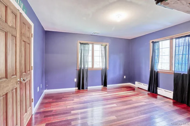 a view of a room with wooden floor and windows