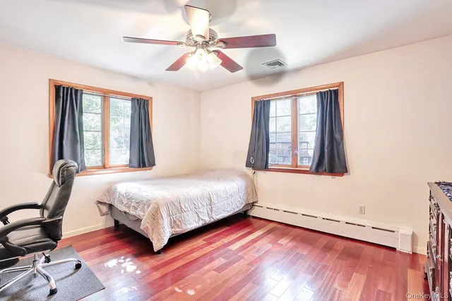a bedroom with a bed dresser and a window