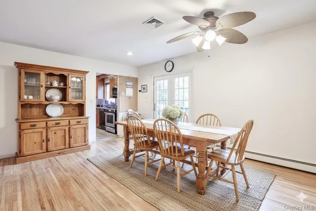 a view of a dining room with furniture a chandelier and wooden floor