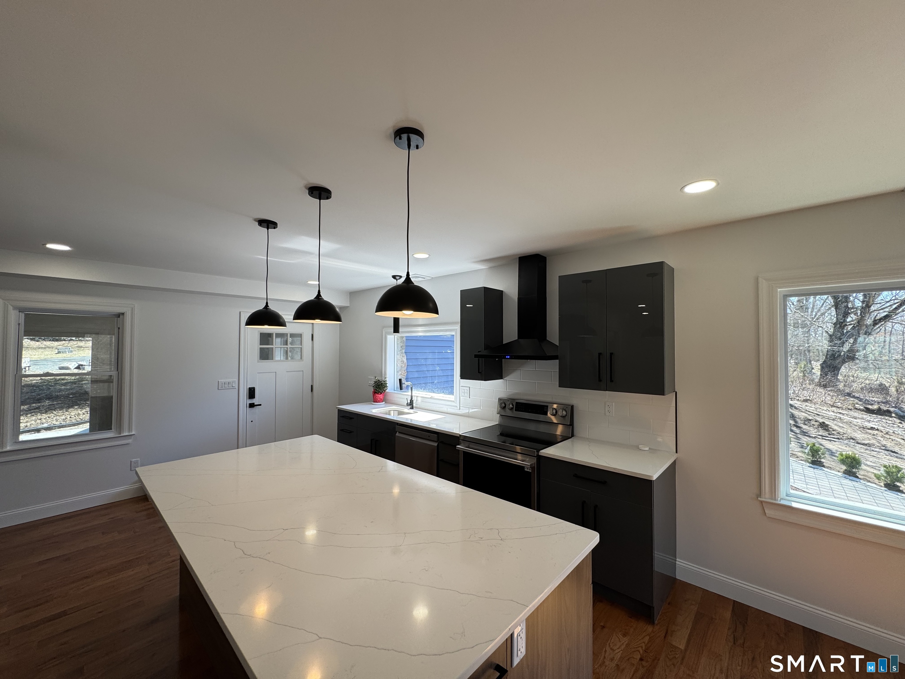 243 Long Hill Road Andover, CT 06232 - Photo 9 of 31 a kitchen with stainless steel appliances kitchen island granite countertop a stove a sink a refrigerator and white cabinets with wooden floor