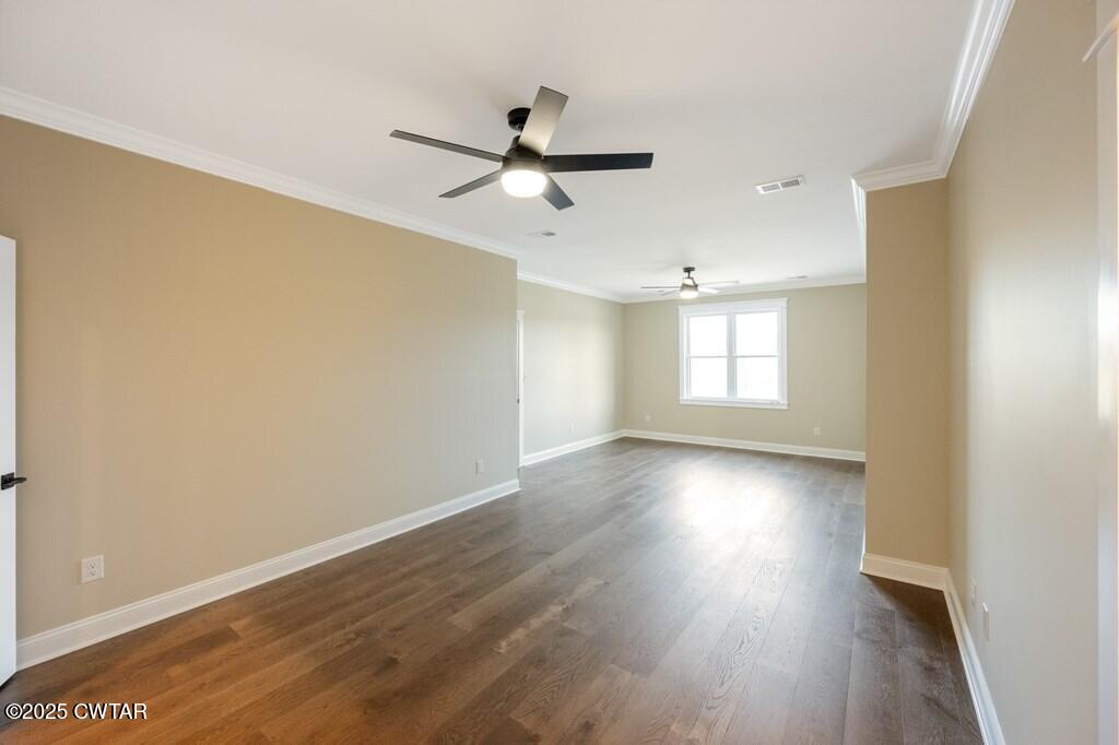 425 Shoreview Lane Huntingdon, TN 38344 - Photo 58 of 65 an empty room with wooden floor ceiling fan and windows