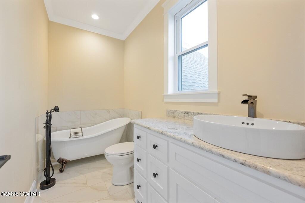 425 Shoreview Lane Huntingdon, TN 38344 - Photo 63 of 65 a bathroom with a granite countertop sink a toilet and a bathtub