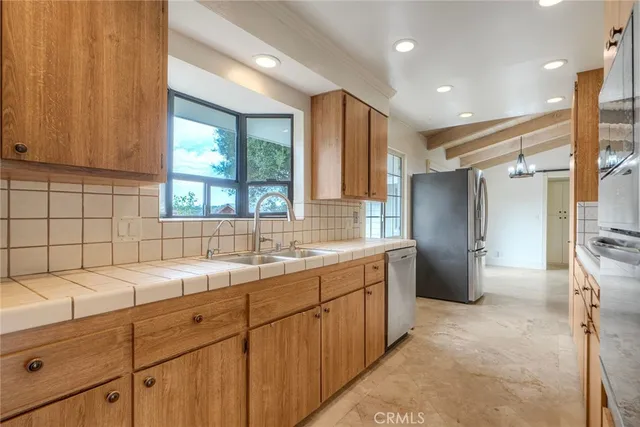 a kitchen with a sink refrigerator and window