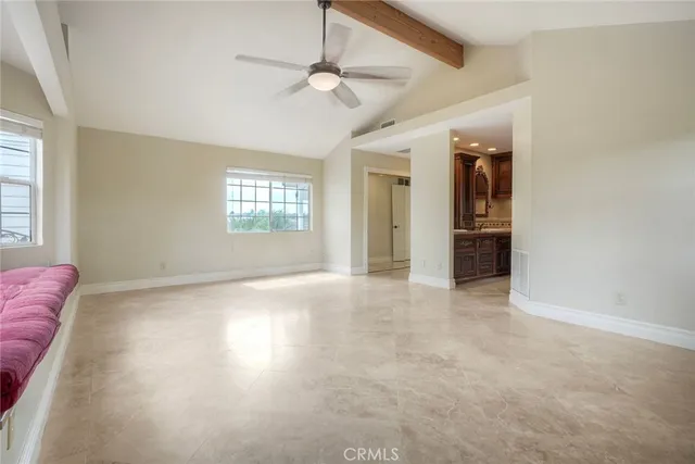 an empty room with windows and ceiling fan