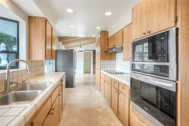 a kitchen with a sink stove top oven and refrigerator