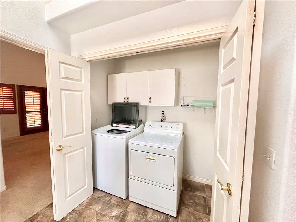 14132 Roxanne Drive Westminster, CA 92683 - Photo 5 of 36 a view of washer and dryer with kitchen in the background
