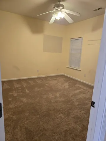 an empty room with a chandelier fan