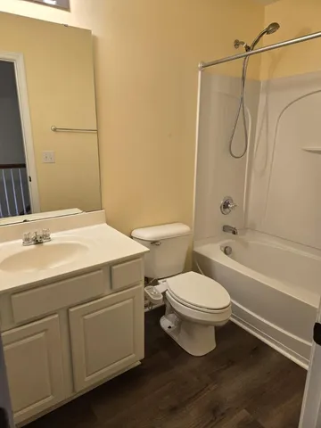 a bathroom with a granite countertop toilet a sink and a mirror