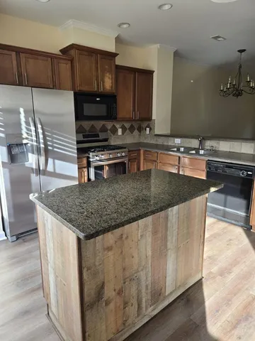 a kitchen with stainless steel appliances granite countertop a stove a sink a microwave and a refrigerator