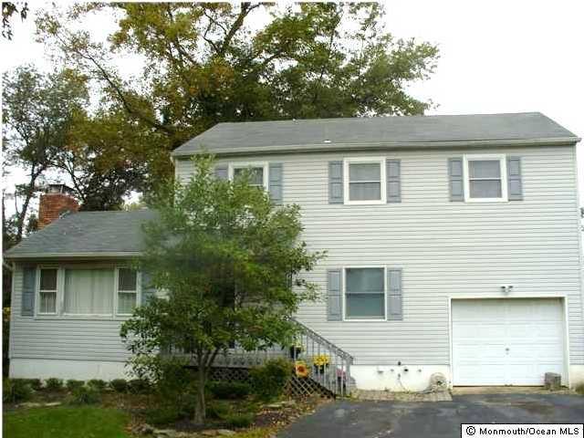 75 Lloyd Road Morganville, NJ 07751 - Photo 1 of 3 a front view of a house with a yard and garage
