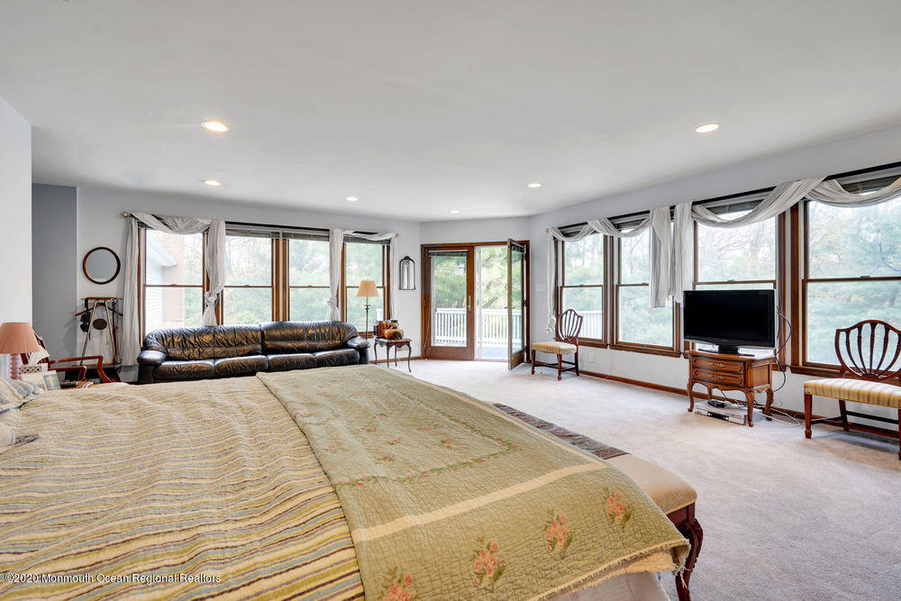 16 Woods Road West Long Branch, NJ 07764 - Photo 27 of 38 a spacious bedroom with a bed a couch and large window in it
