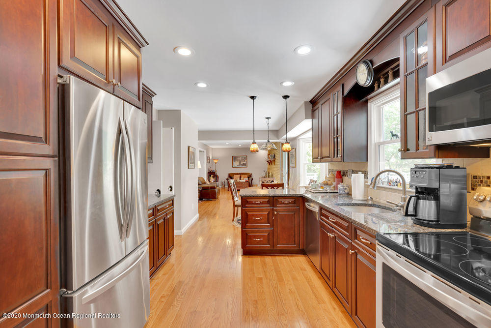 16 Woods Road West Long Branch, NJ 07764 - Photo 10 of 38 a large kitchen with stainless steel appliances granite countertop a refrigerator a sink dishwasher a stove and white cabinets with wooden floor