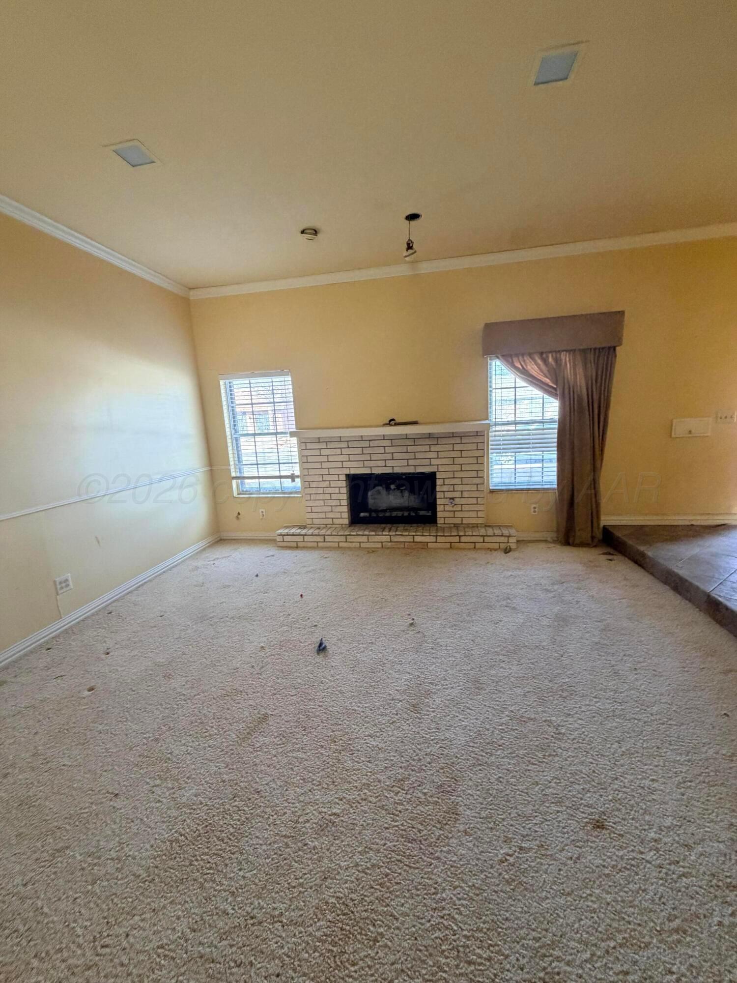 3113 Southwest 28th Avenue Amarillo, TX 79109 - Photo 5 of 10 an empty room with a fireplace and window