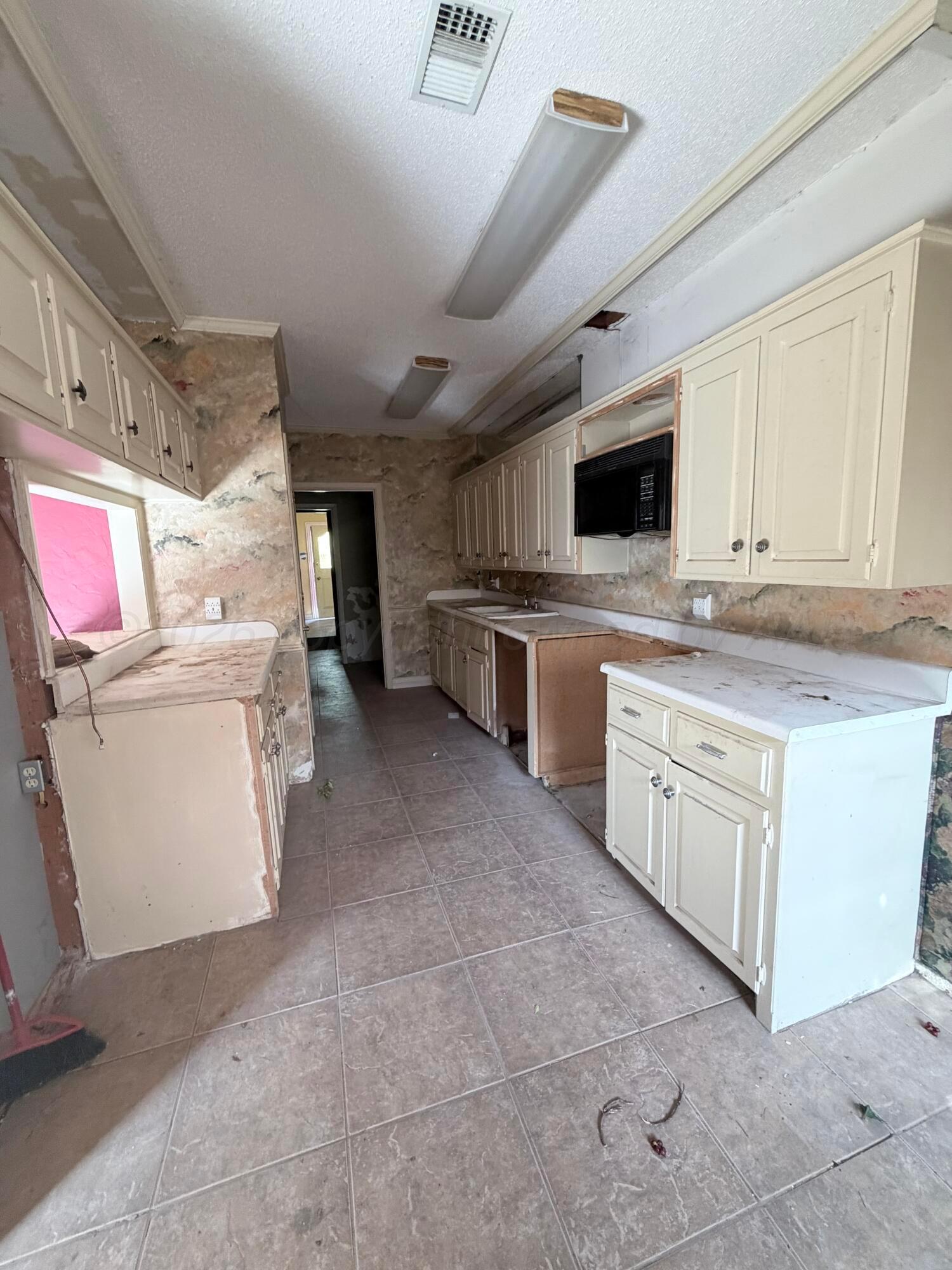 3113 Southwest 28th Avenue Amarillo, TX 79109 - Photo 8 of 10 a kitchen with a stove top oven and cabinets
