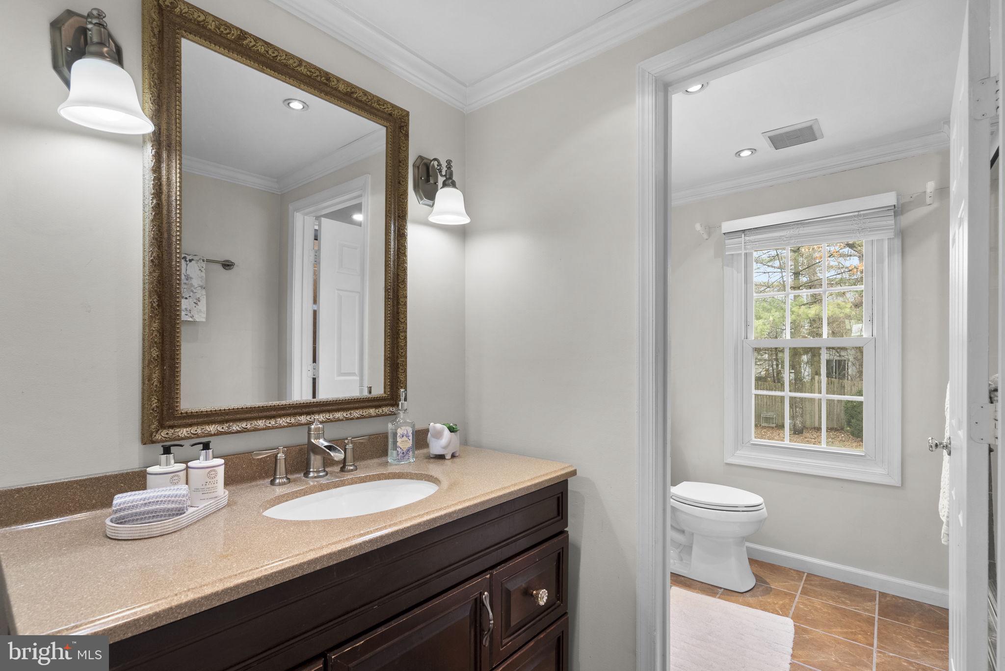 14908 Village Gate Drive Silver Spring, MD 20906 - Photo 27 of 57 a bathroom with double vanity sinks a toilet and a mirror