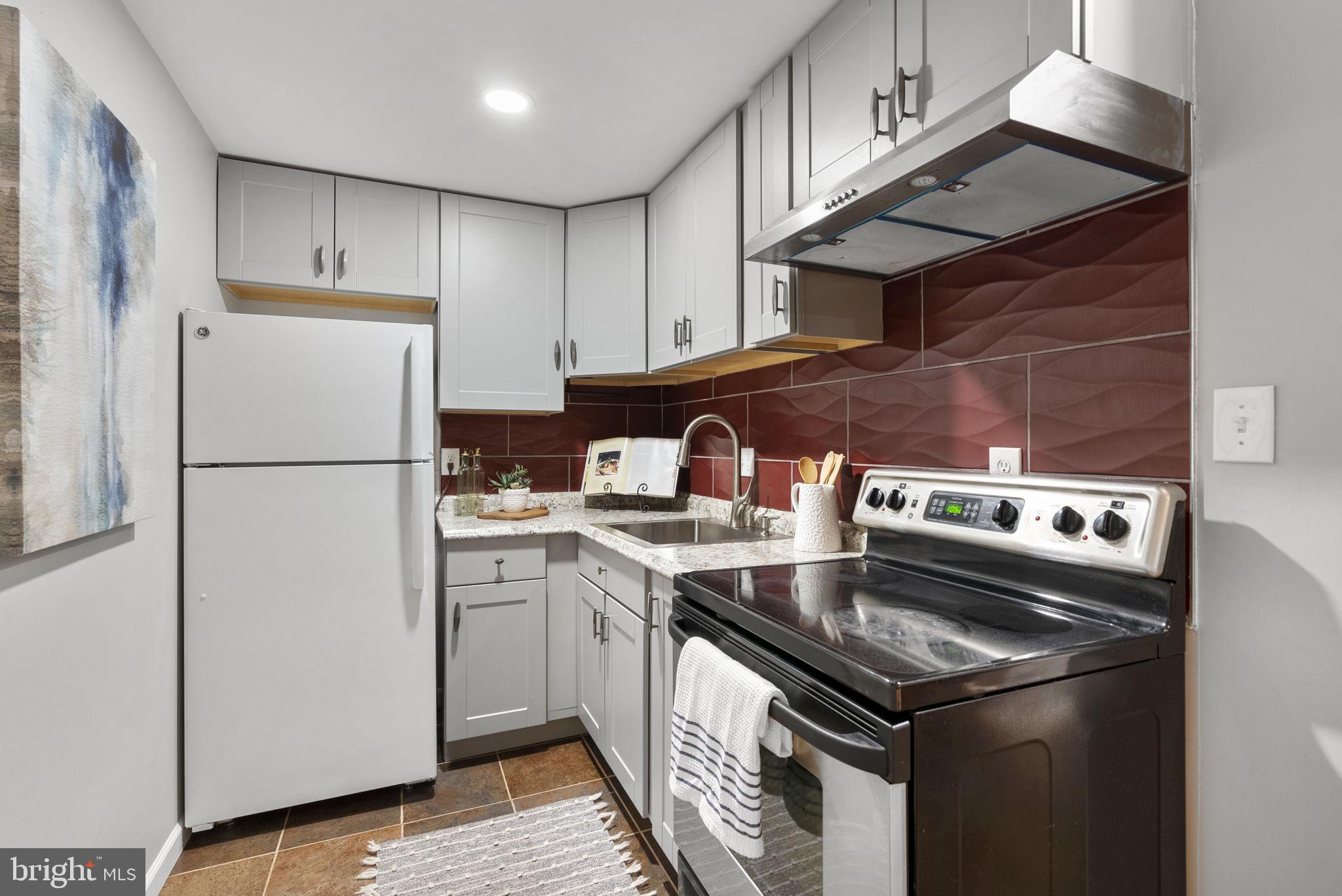 14908 Village Gate Drive Silver Spring, MD 20906 - Photo 31 of 57 a kitchen with stainless steel appliances granite countertop a stove a refrigerator and a sink