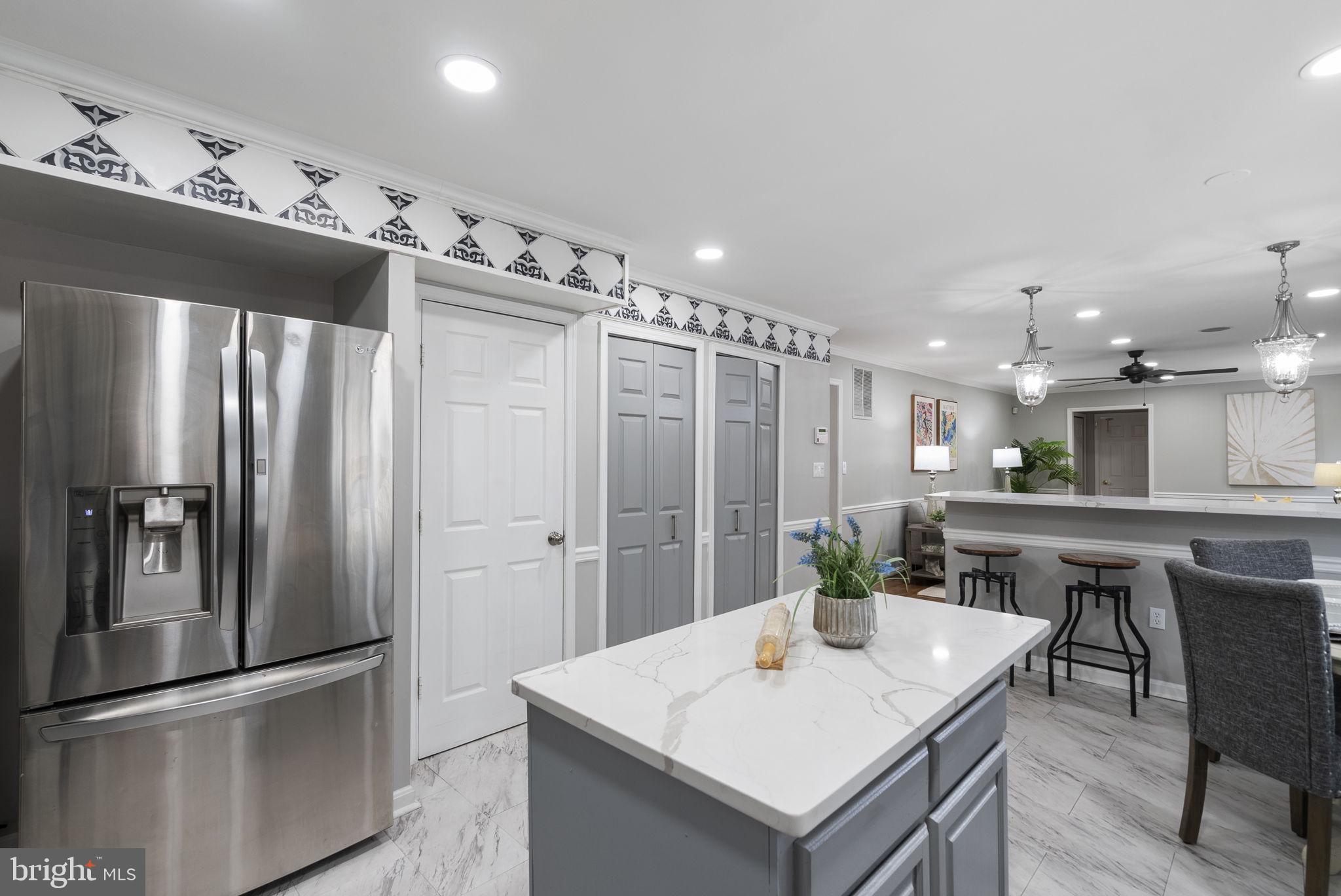 14908 Village Gate Drive Silver Spring, MD 20906 - Photo 6 of 57 a kitchen with a refrigerator a sink and chairs