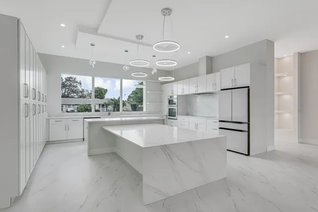 a kitchen with stainless steel appliances white cabinets and a fireplace