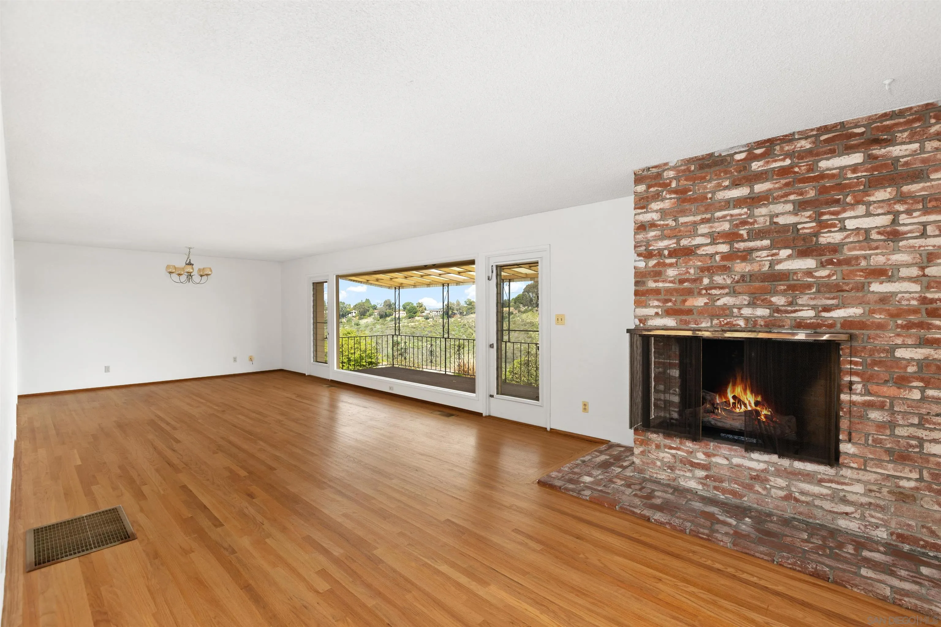a view of empty room with wooden floor and fireplace