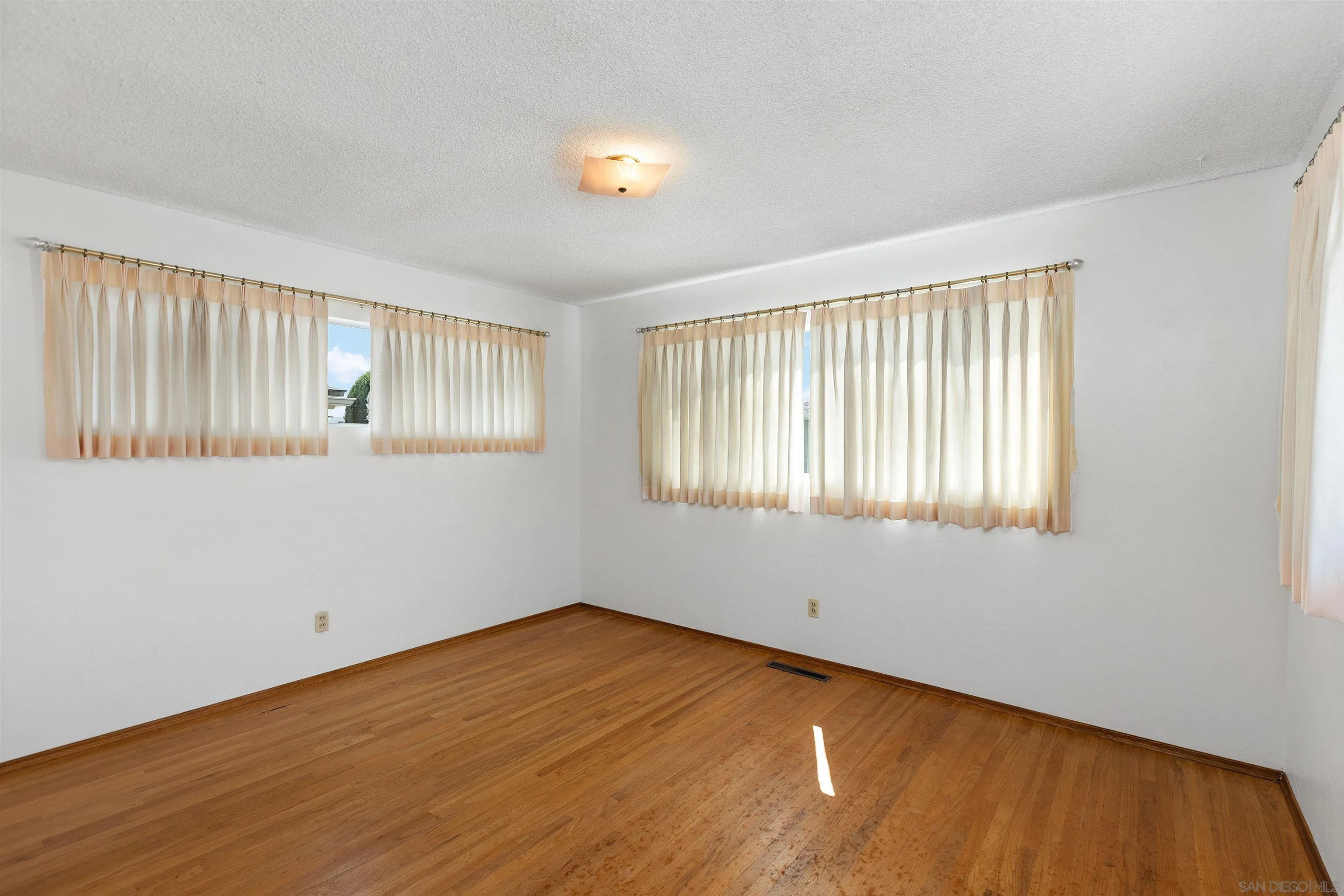 4552 Lucille Drive San Diego, CA 92115 - Photo 15 of 35 a view of an empty room with wooden floor and a window