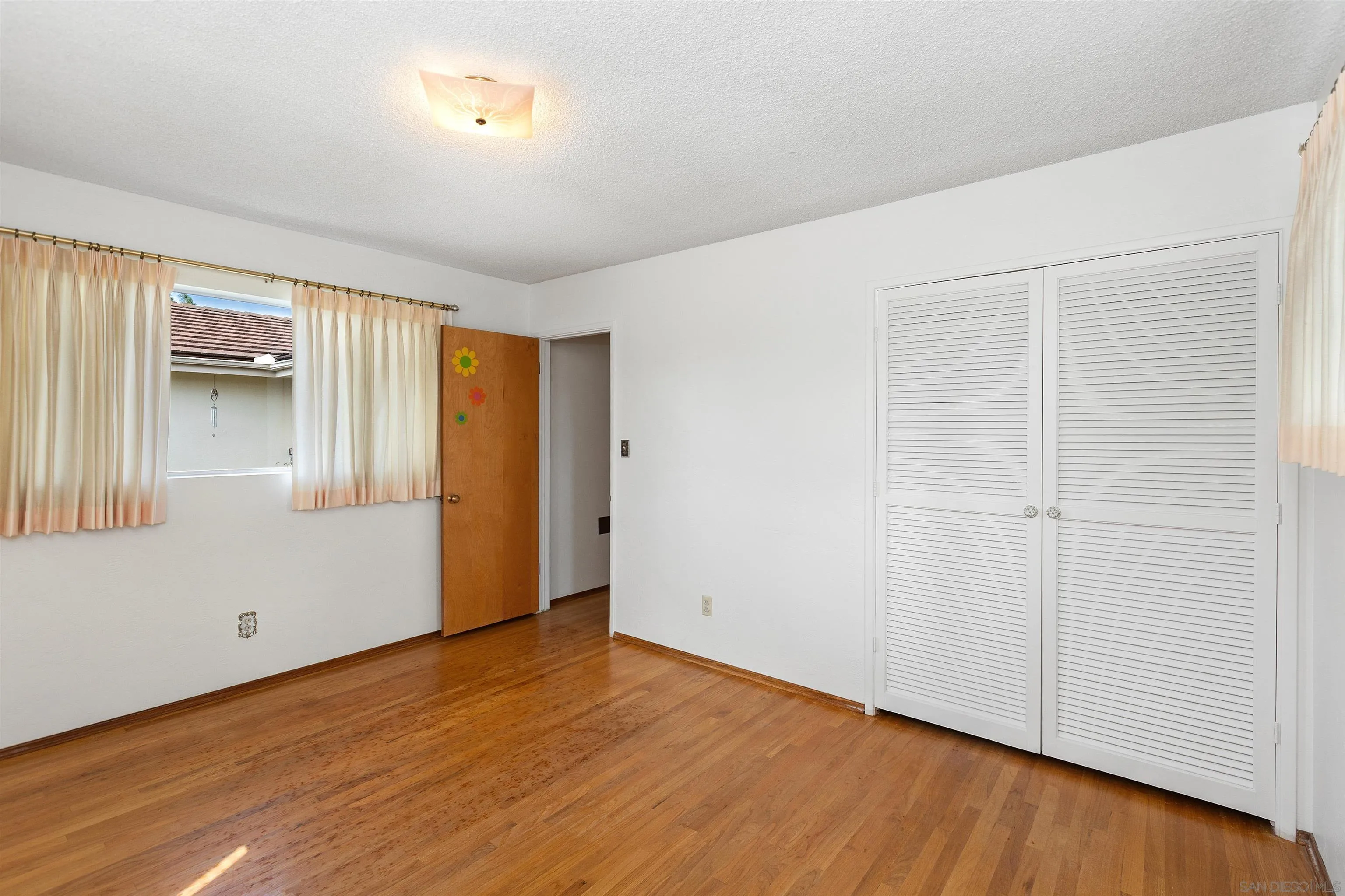 4552 Lucille Drive San Diego, CA 92115 - Photo 16 of 35 an empty room with wooden floor and windows