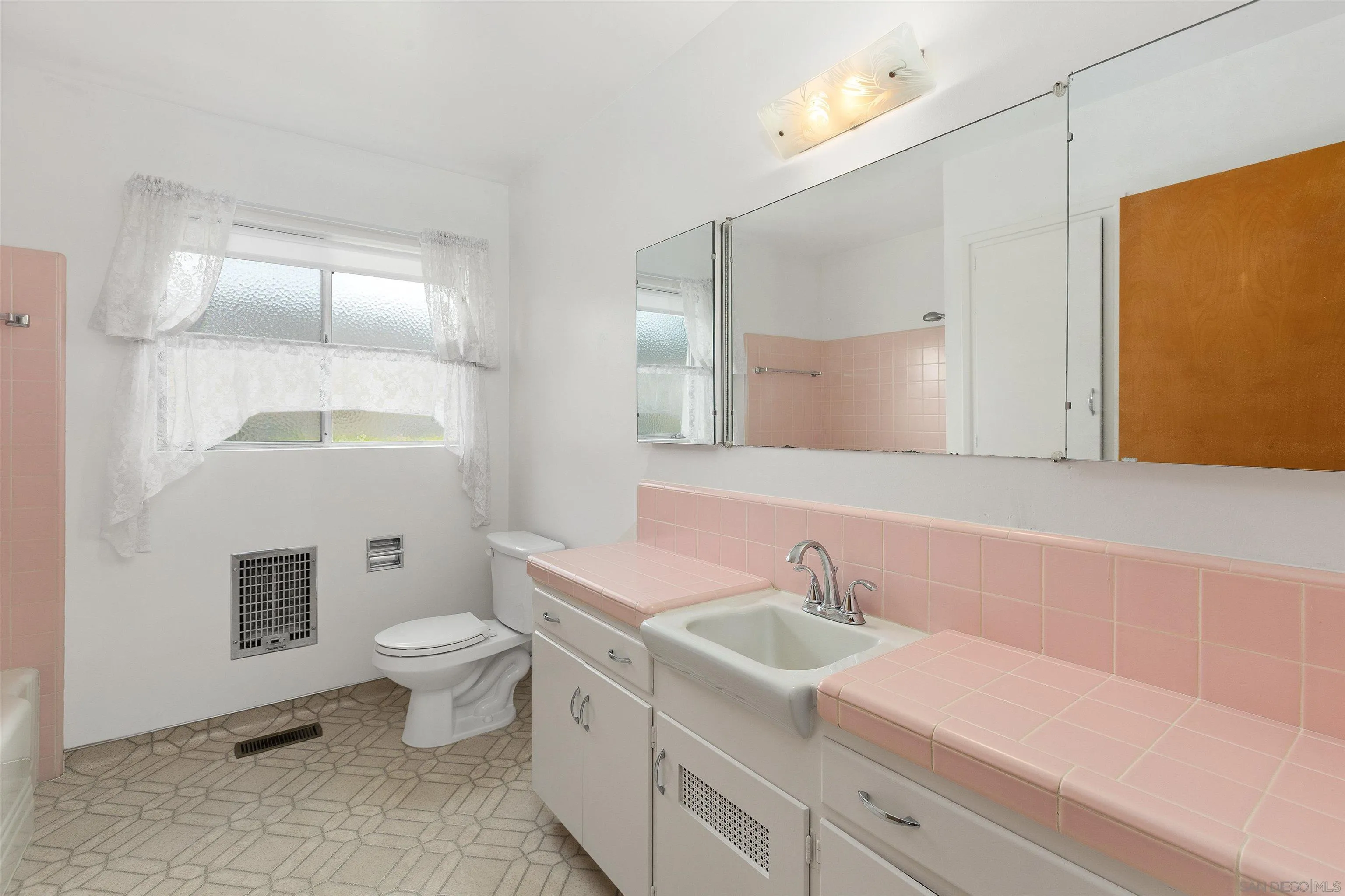 4552 Lucille Drive San Diego, CA 92115 - Photo 17 of 35 a bathroom with a sink toilet a mirror and shower