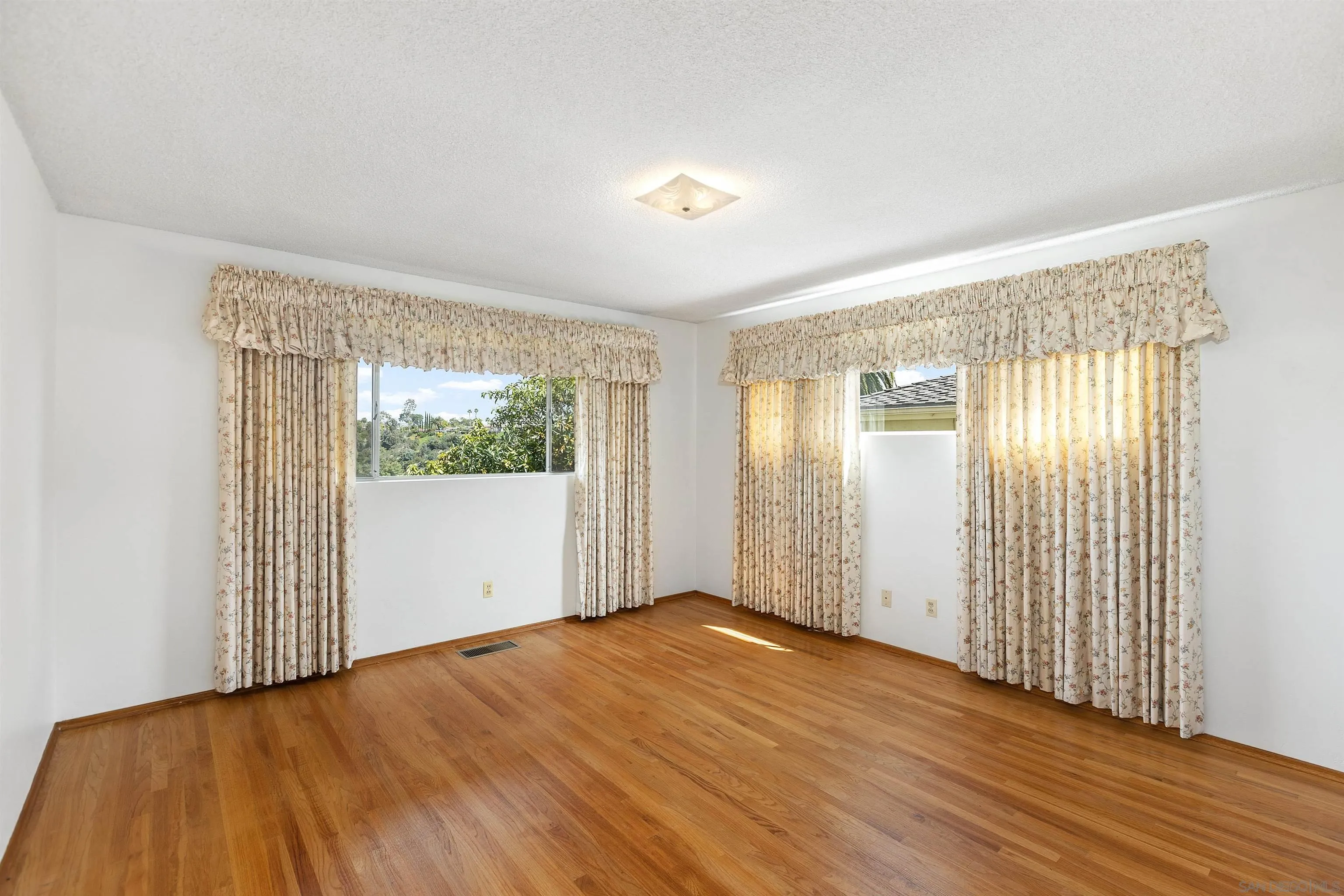 4552 Lucille Drive San Diego, CA 92115 - Photo 18 of 35 an empty room with wooden floor and windows