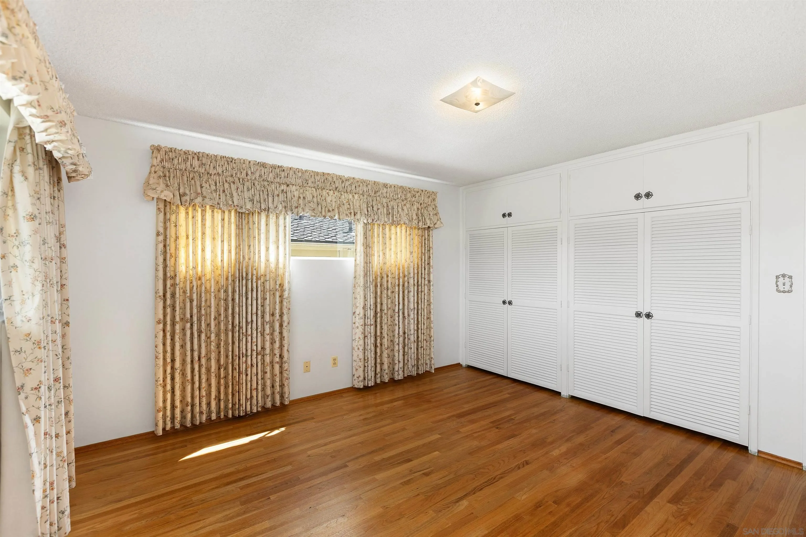 4552 Lucille Drive San Diego, CA 92115 - Photo 19 of 35 an empty room with wooden floor and windows