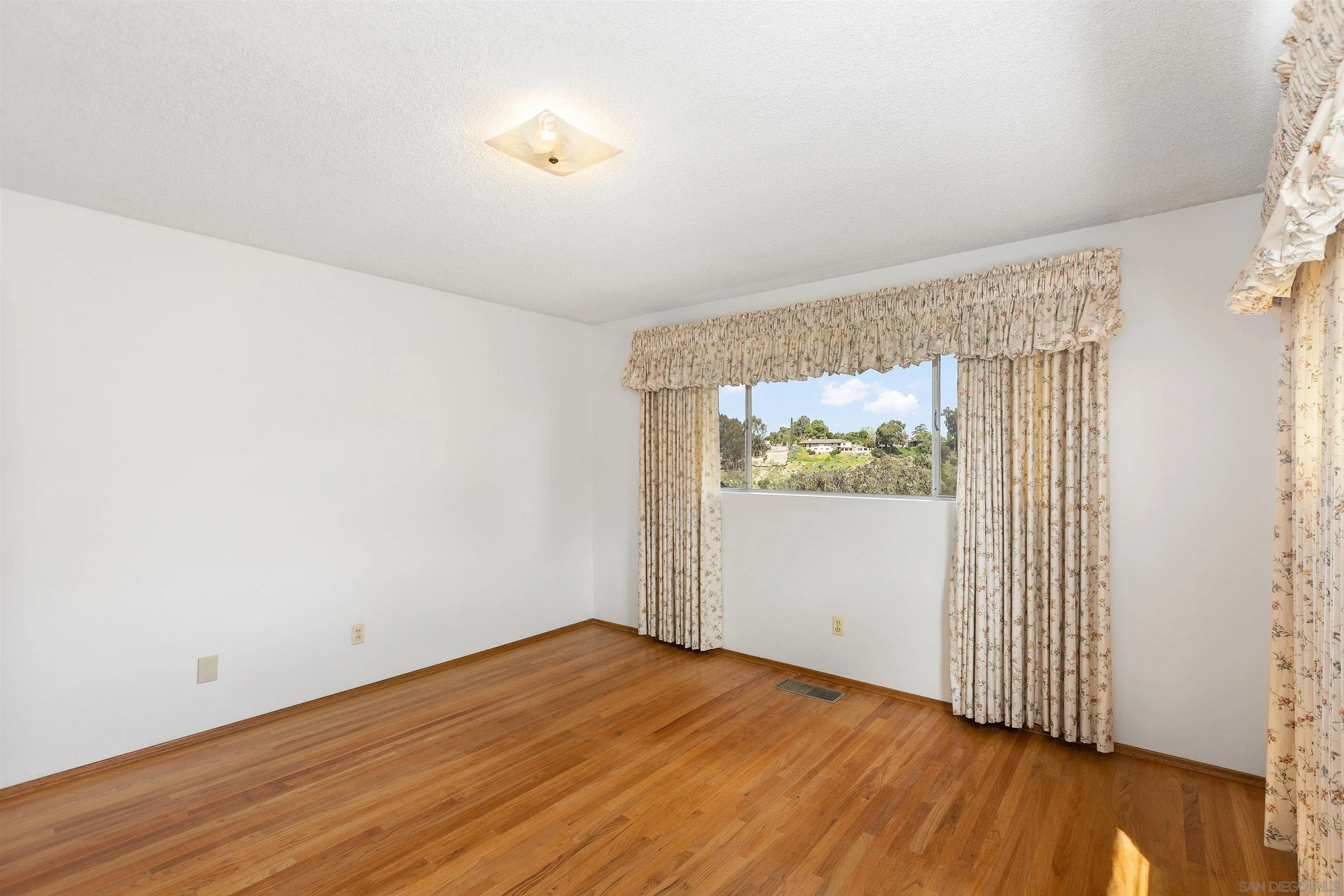 4552 Lucille Drive San Diego, CA 92115 - Photo 21 of 35 an empty room with wooden floor and windows