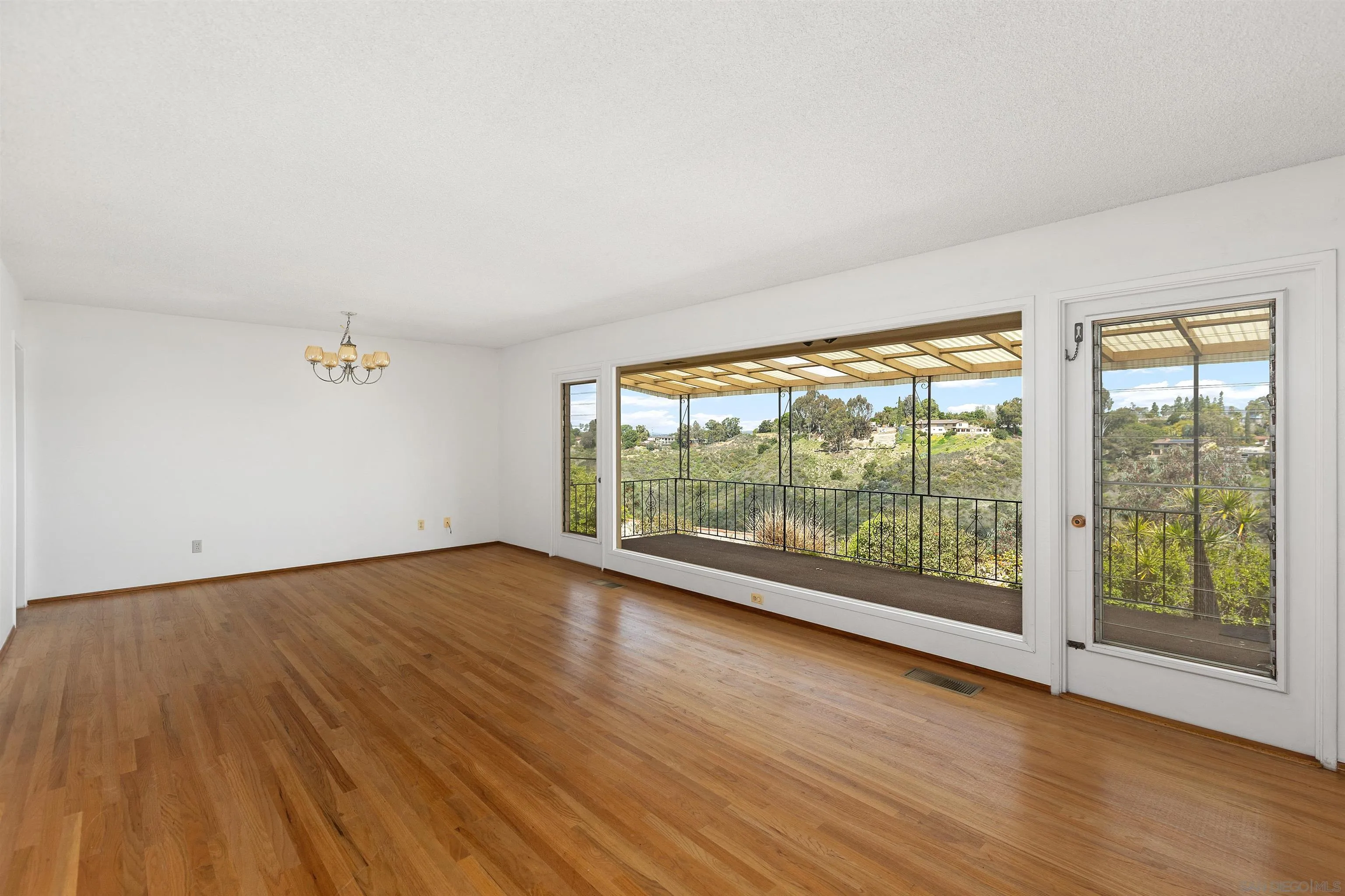 4552 Lucille Drive San Diego, CA 92115 - Photo 5 of 35 an empty room with wooden floor and windows