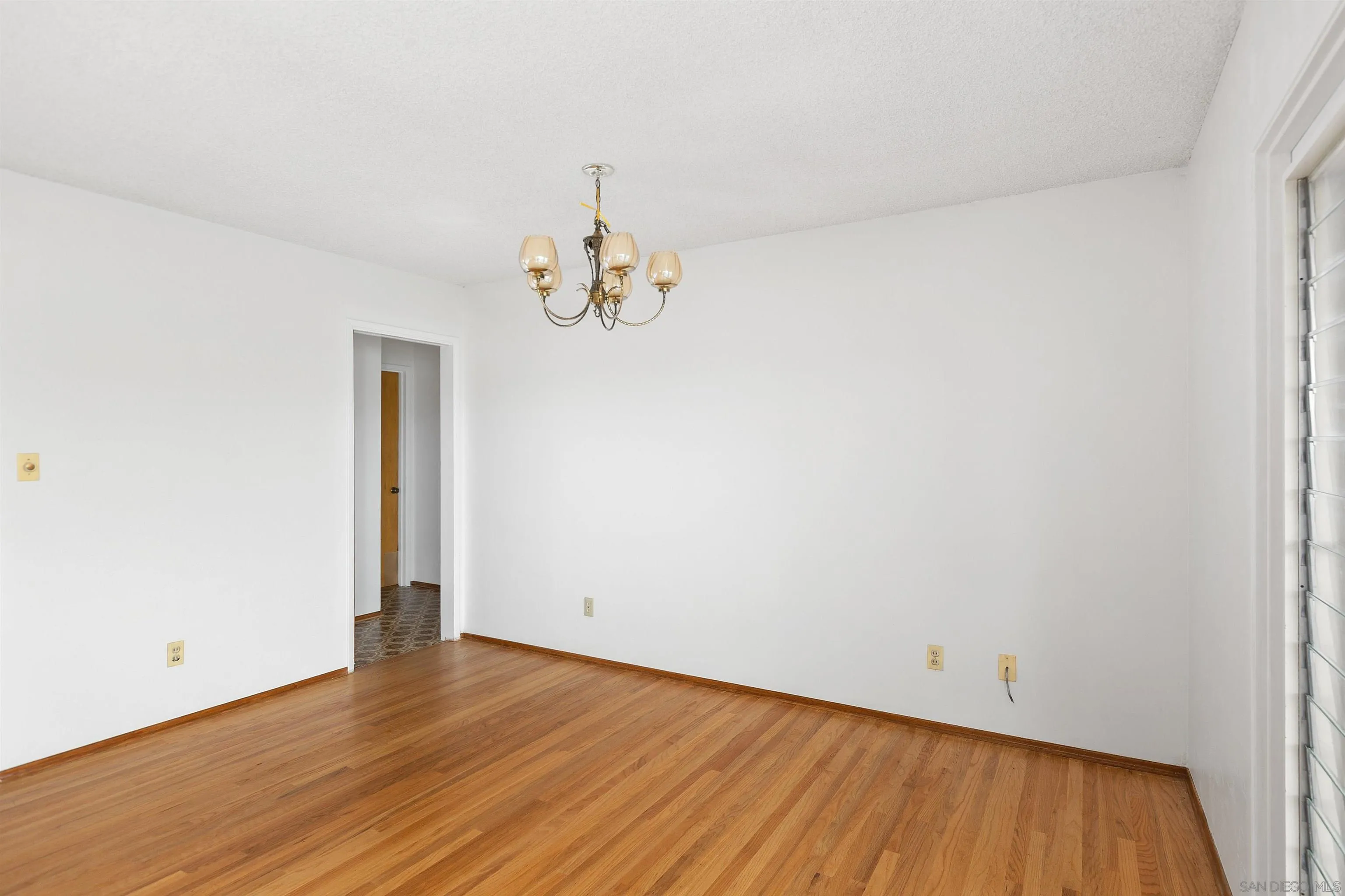 4552 Lucille Drive San Diego, CA 92115 - Photo 8 of 35 a view of an empty room with wooden floor and a window