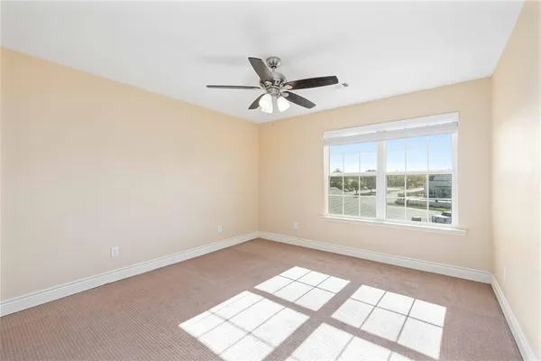 an empty room with a window and a fan