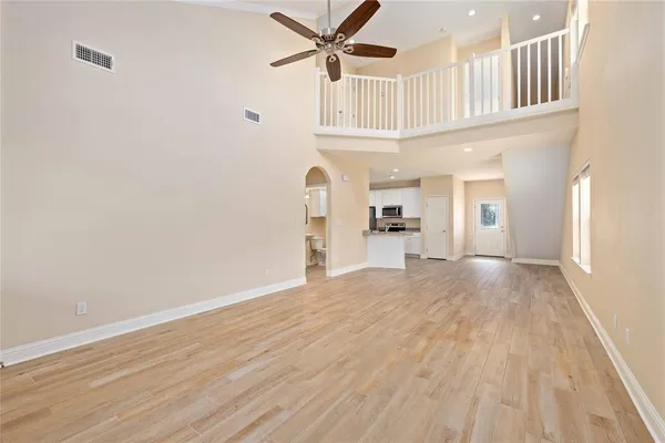 a view of a kitchen with wooden floor and a ceiling fan