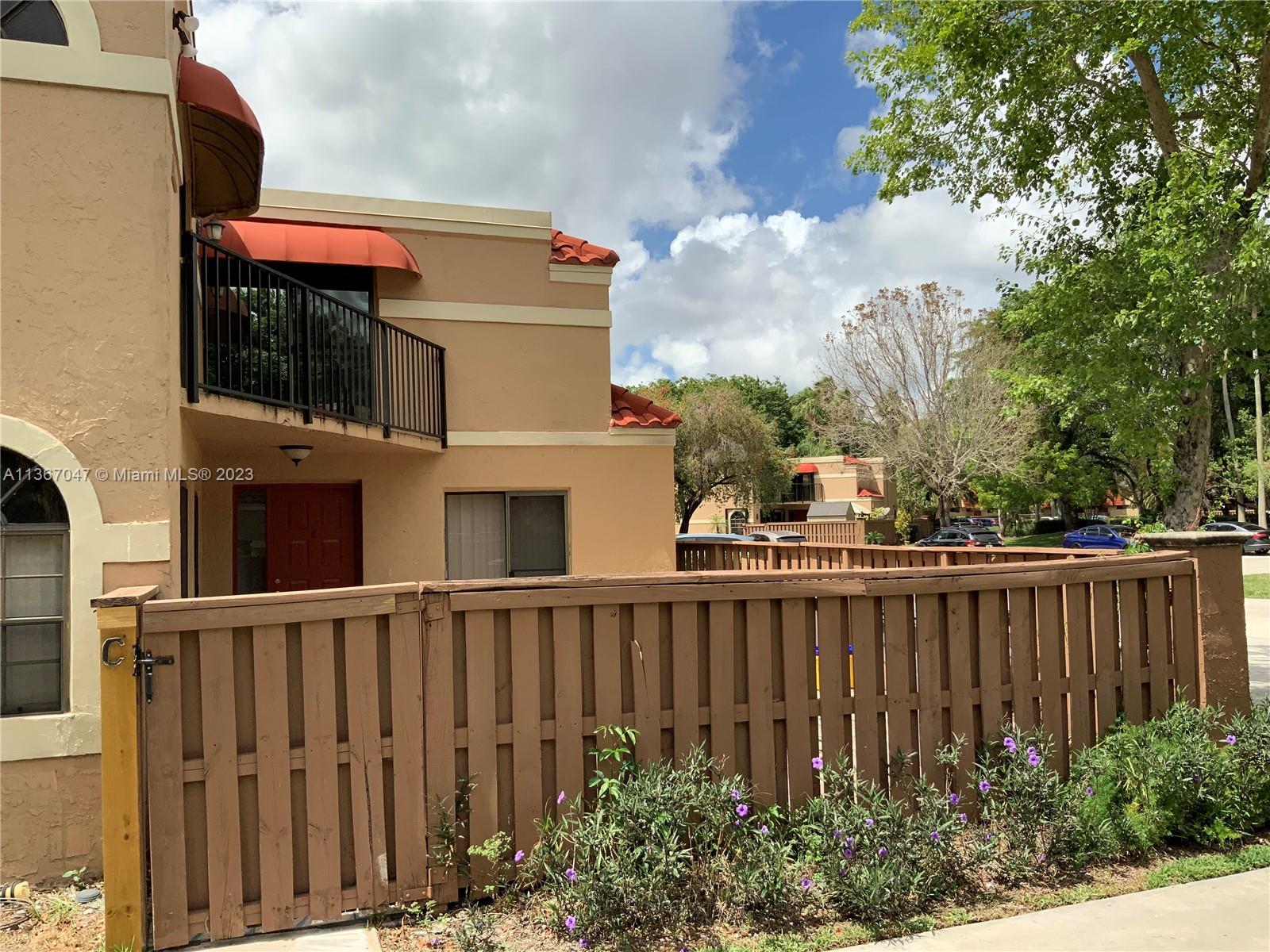 8110 Severn Drive, Unit C Boca Raton, FL 33433 - Photo 2 of 31 a view of a brick house with a large window and wooden fence
