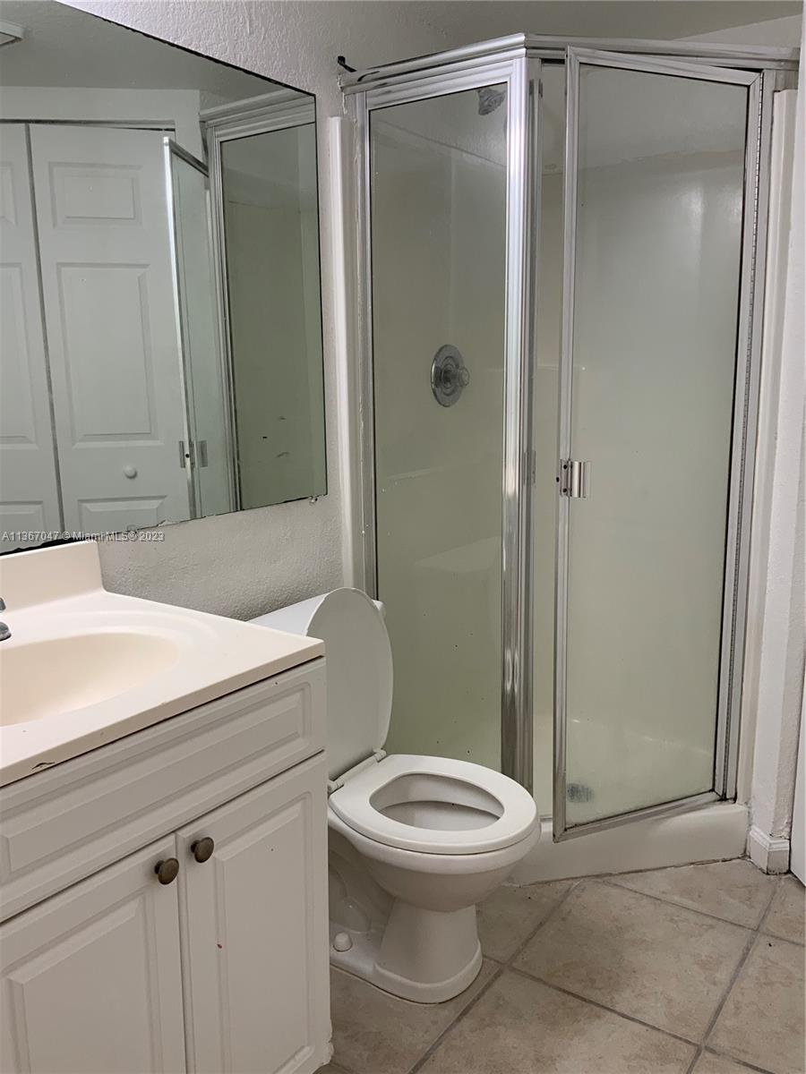 8110 Severn Drive, Unit C Boca Raton, FL 33433 - Photo 6 of 31 a bathroom with a toilet a sink and shower