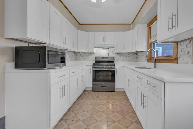 a kitchen with granite countertop white cabinets and stainless steel appliances
