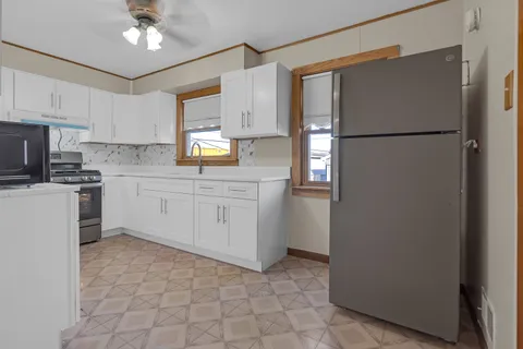 a kitchen with a refrigerator a sink and cabinets