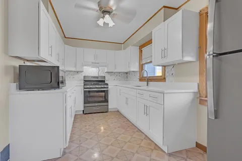 a kitchen with cabinets stainless steel appliances and a counter space