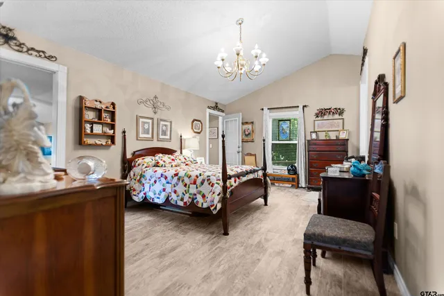 a bedroom with bed and a chandelier