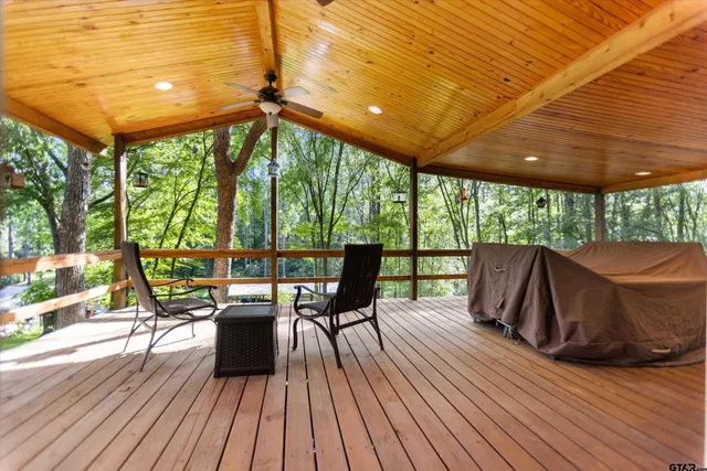 a view of a patio with table and chairs under an umbrella with wooden floor