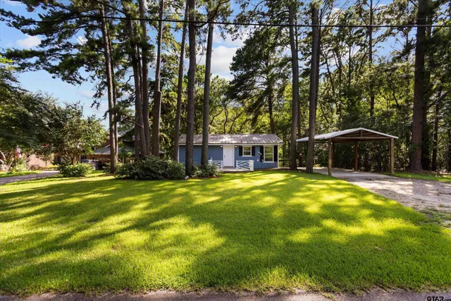 a front view of a house with swimming pool and trees