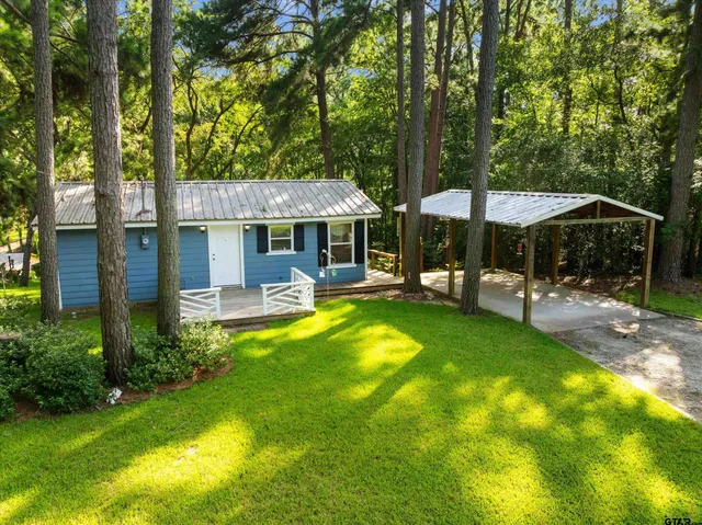 a view of a swimming pool with lawn chairs under an umbrella