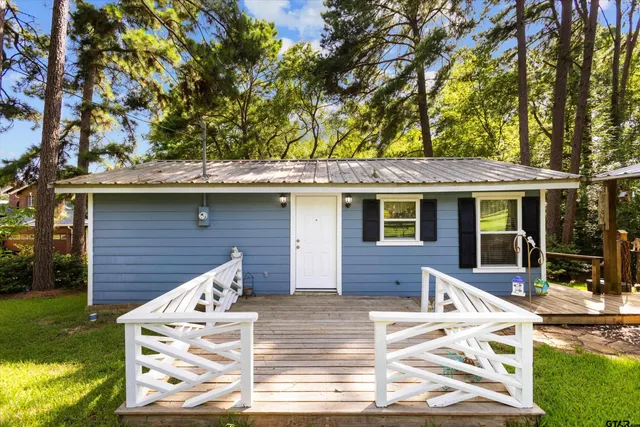 front view of house with table and chairs in a yard