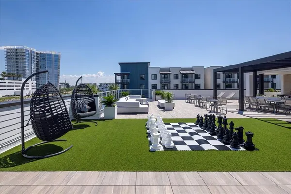 a view of a swimming pool and lounge chairs in back yard of the house