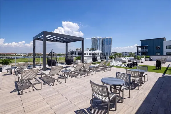 a view of a patio with couches table and chairs under an umbrella